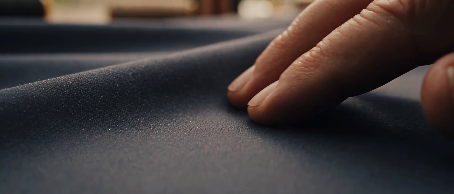 Fingertips resting on navy cloth.