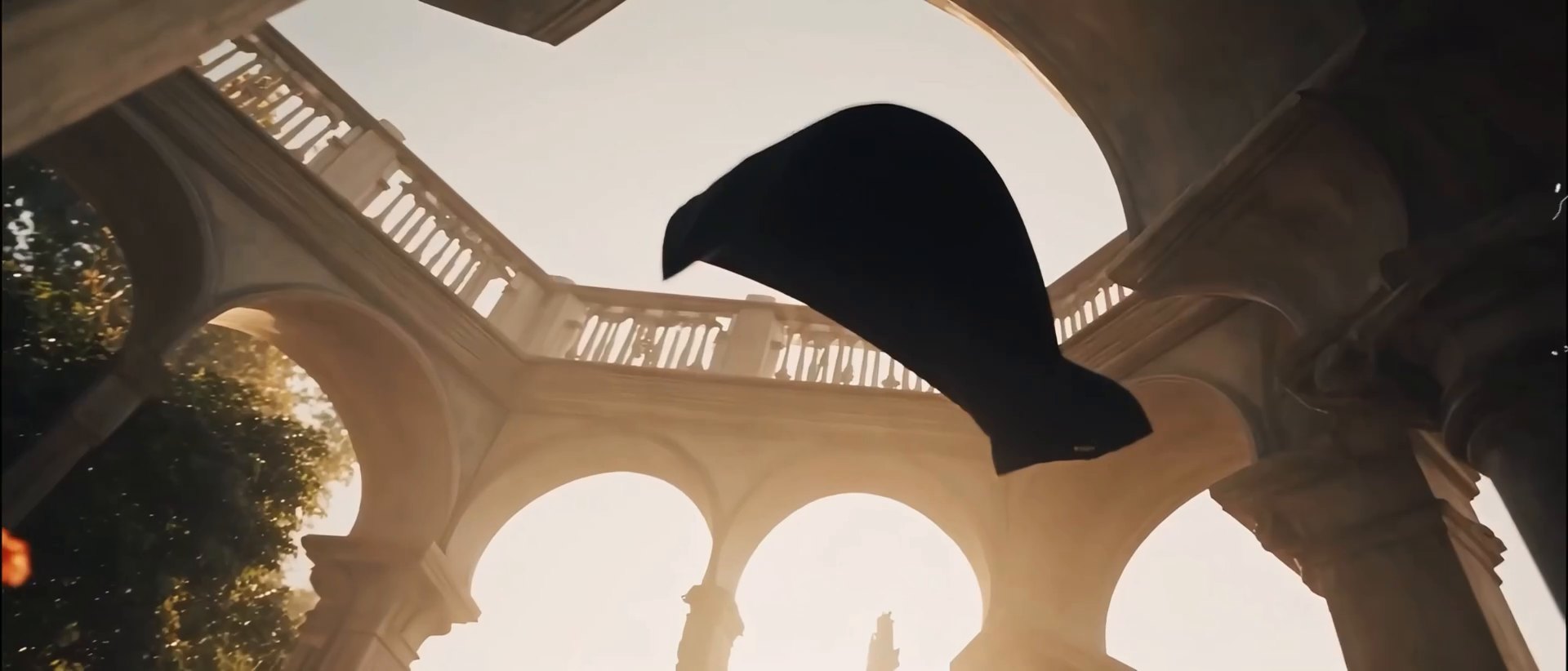 Dark cloth lifting through a sunlit stone colonnade.